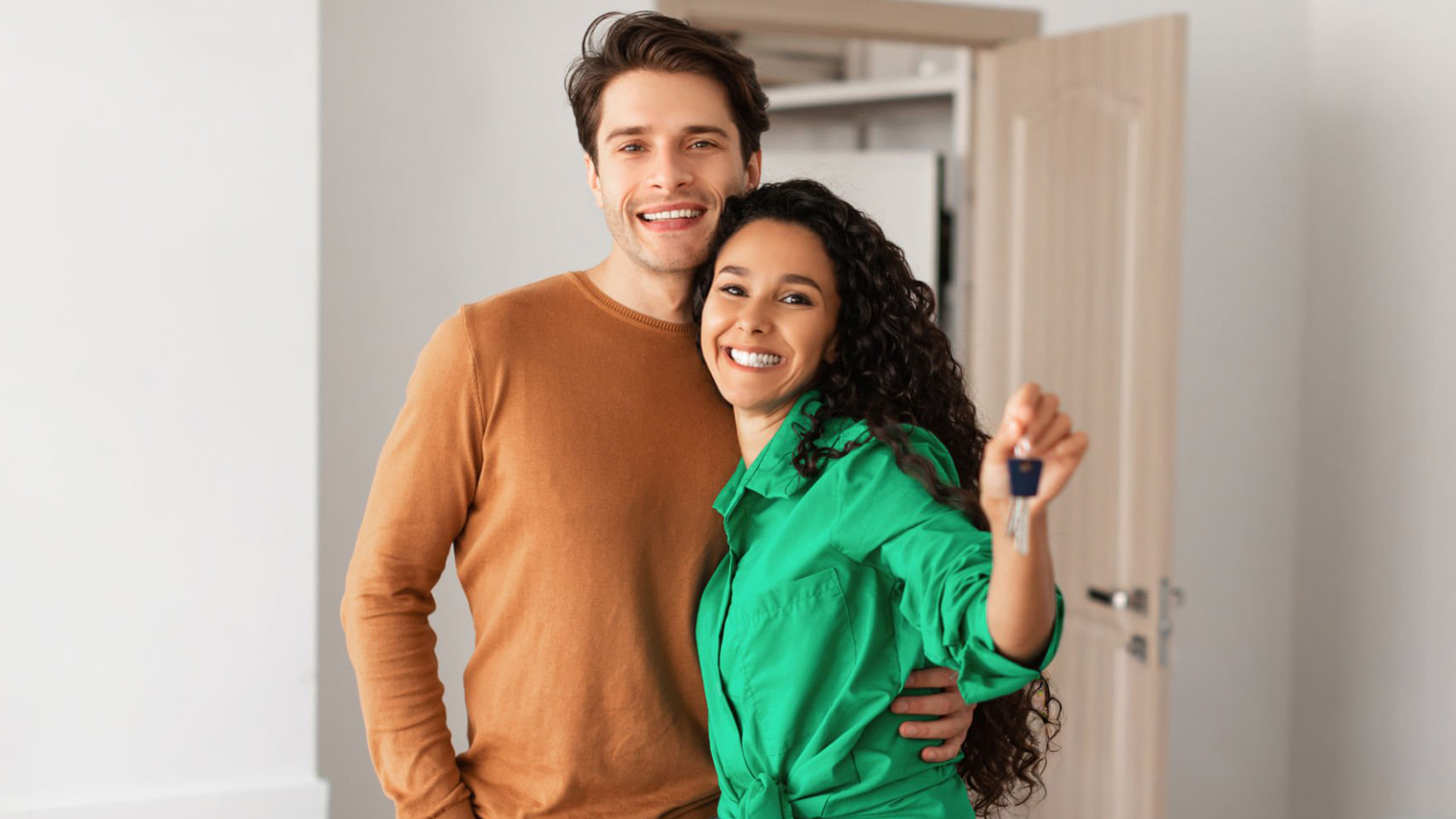 Happy couple holding keys to their new rental home