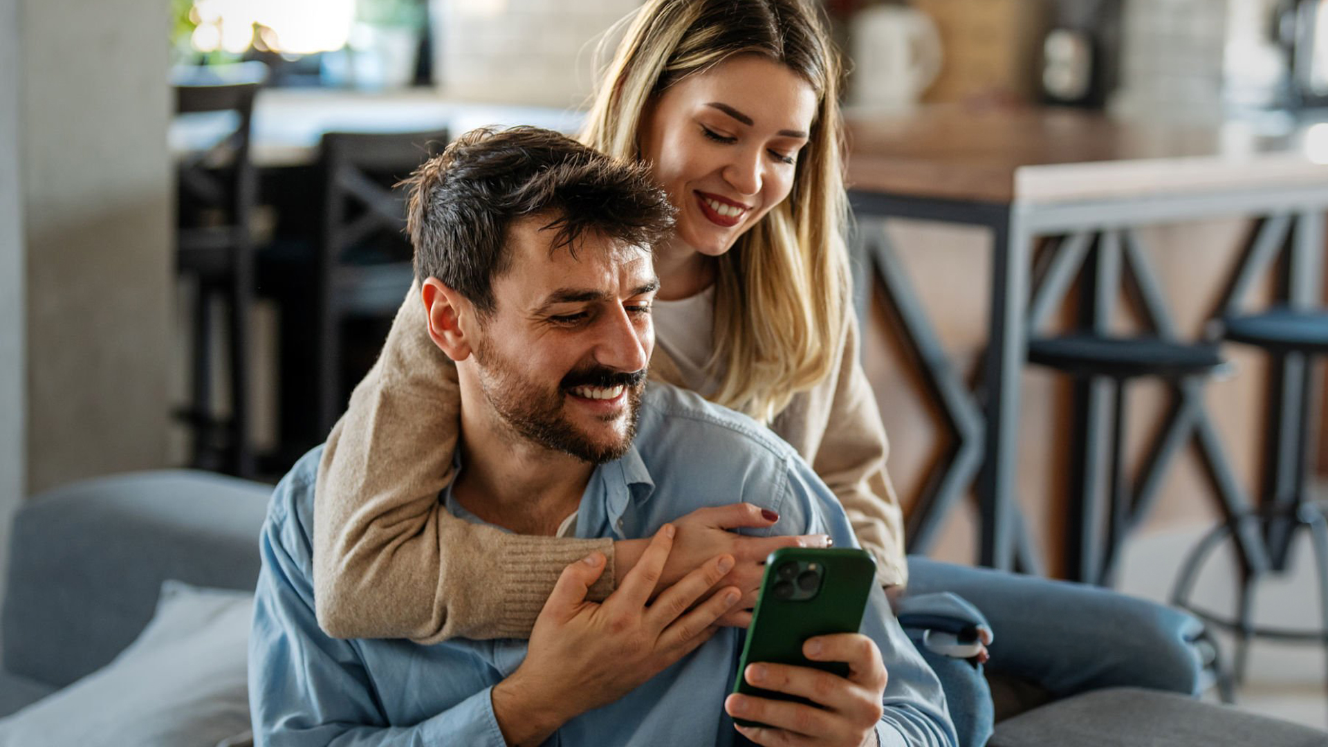 Happy couple engaging with a phone — attention as an asset
